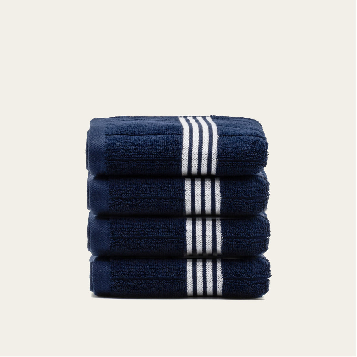 Stack of navy bath towels with white striped bands, folded into a tight bundle