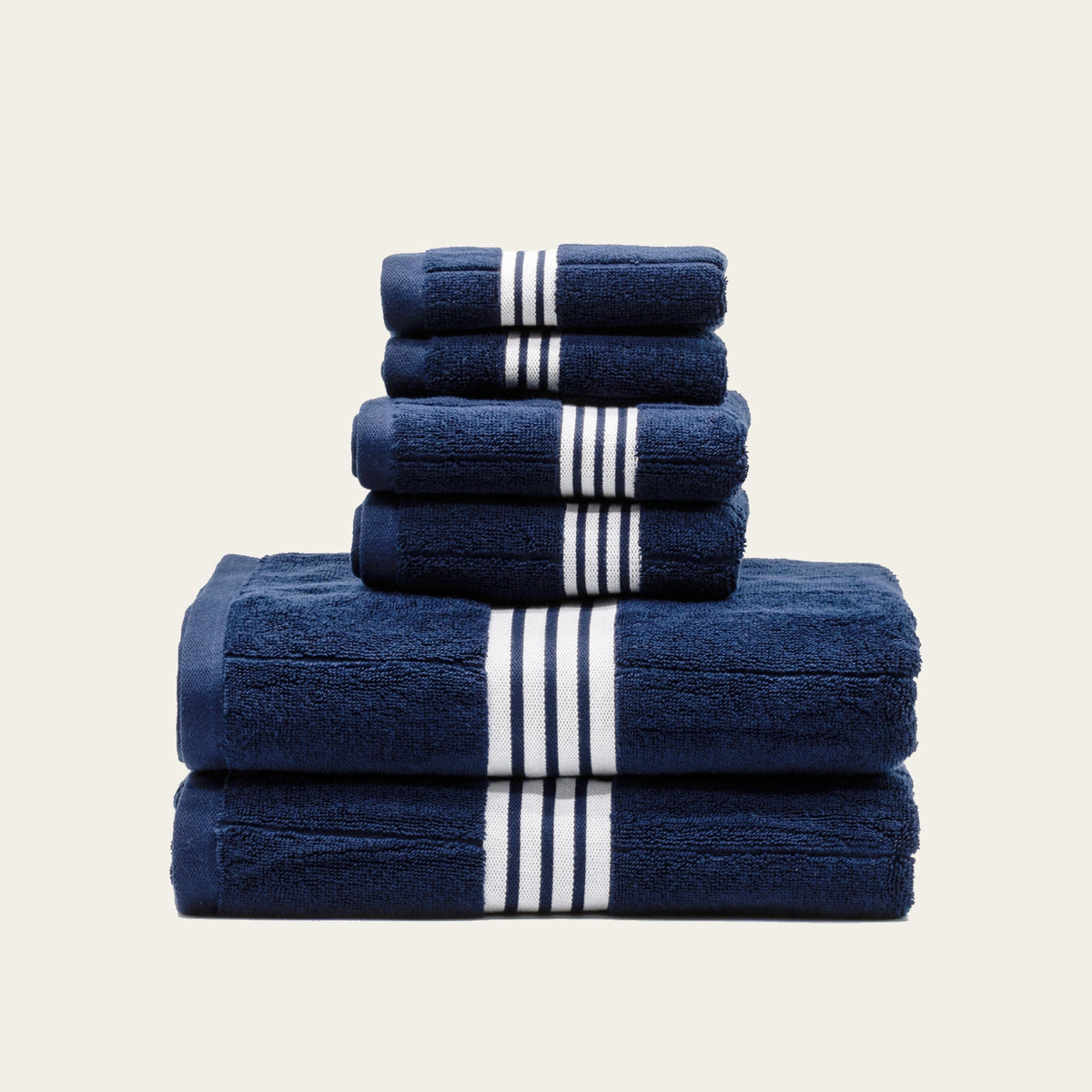 Navy towels folded with white striped bands, with a larger top towel