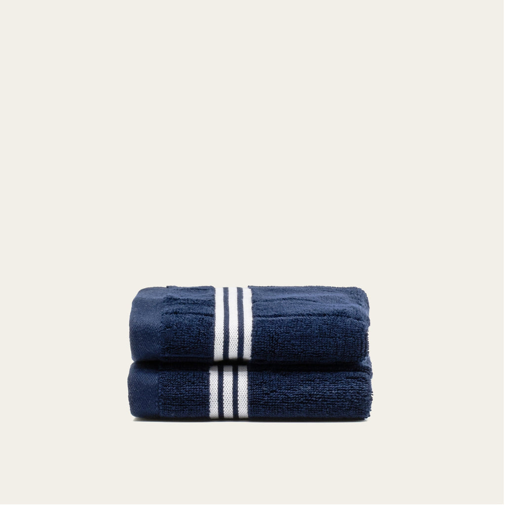 Navy cotton towels with white striped border, folded pair