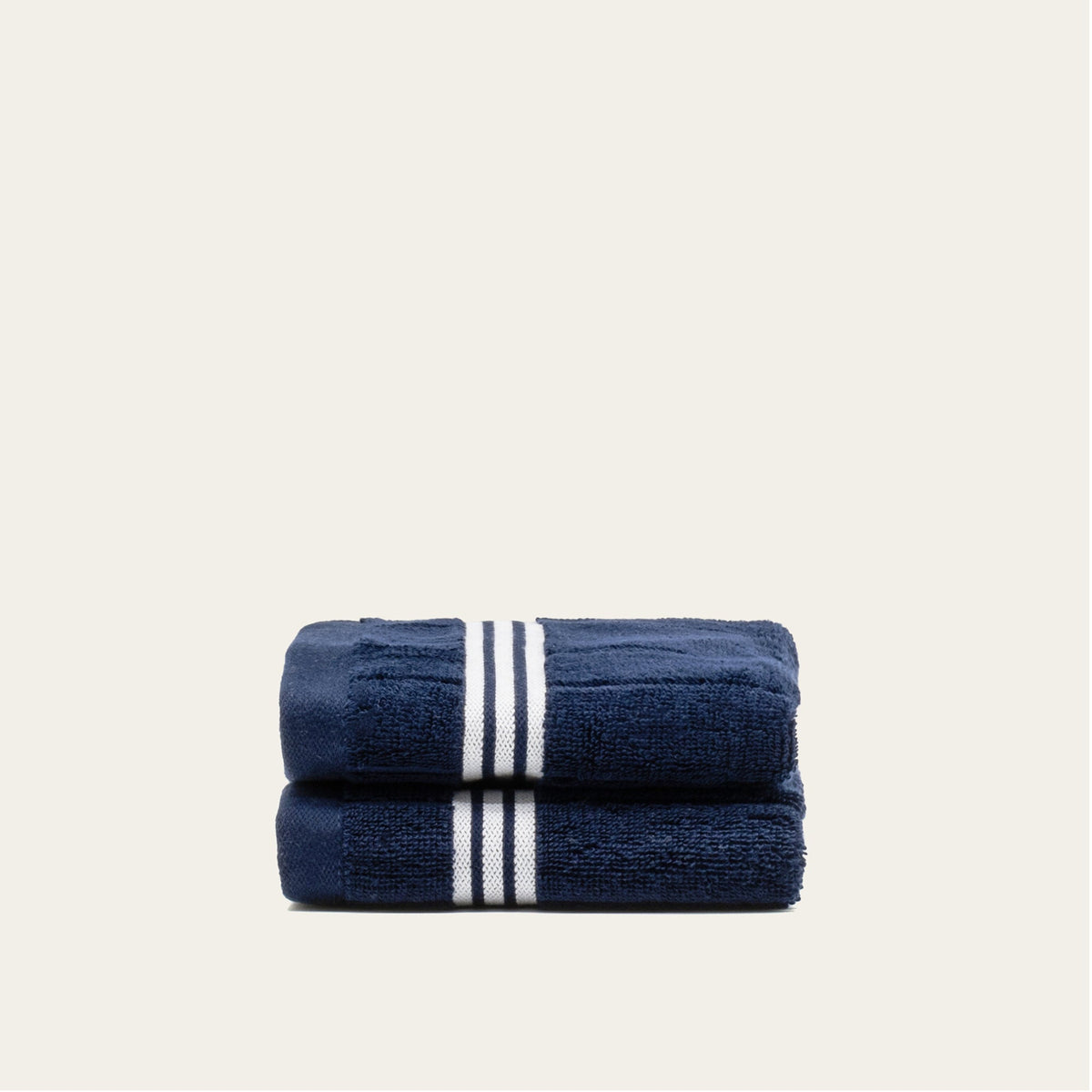 Navy cotton towels with white striped border, folded pair