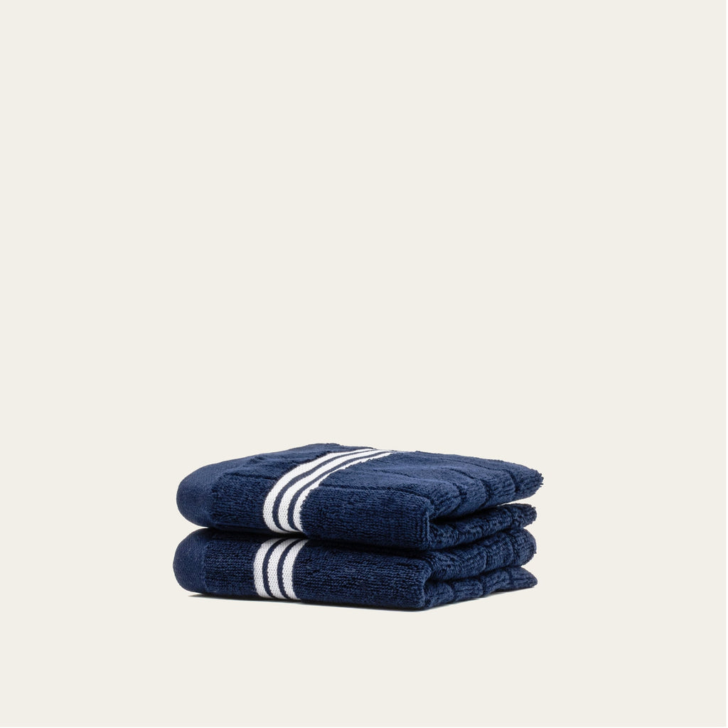 Navy cotton bath towels with white striped trim, folded set of 2