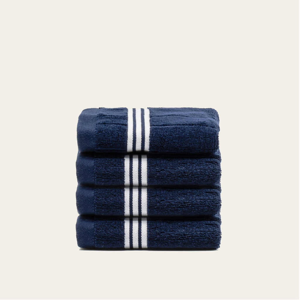 Navy towels with white striped bands, folded into a compact stack