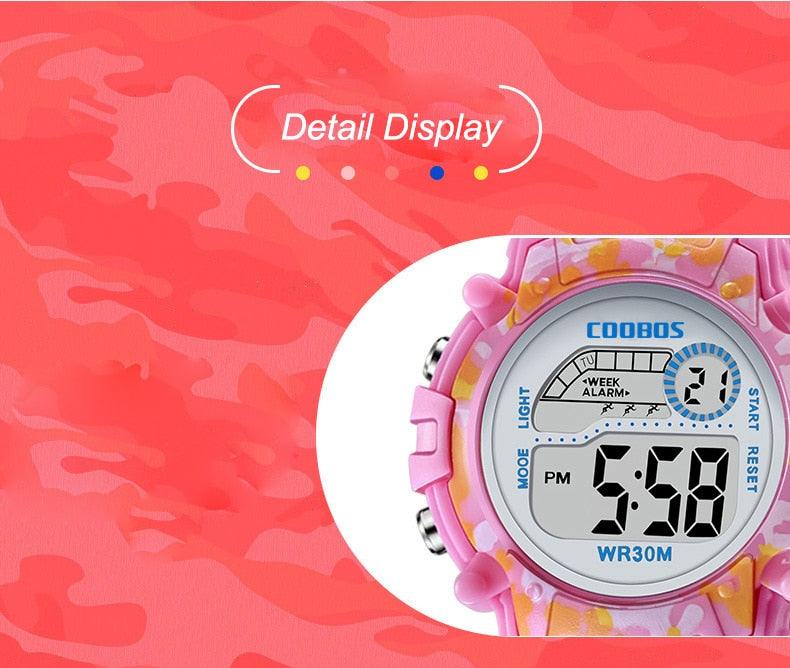 Kids pink digital camouflage LED wristwatch close-up of round LCD display, WR30M.