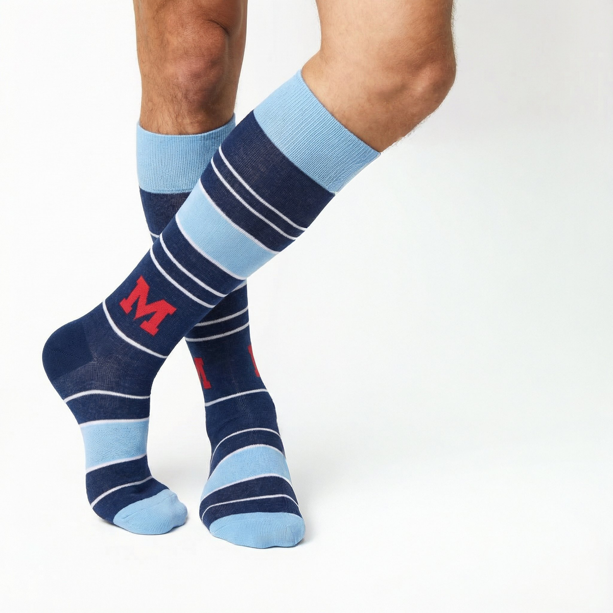 Crew dress socks in navy and light blue stripes with red M logo on wearer