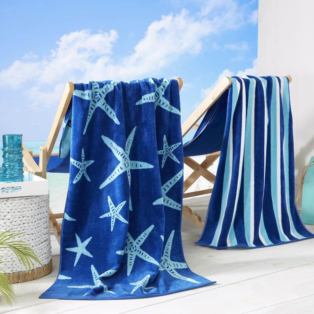 Blue cotton velour beach towel with starfish print draped on a wooden rack