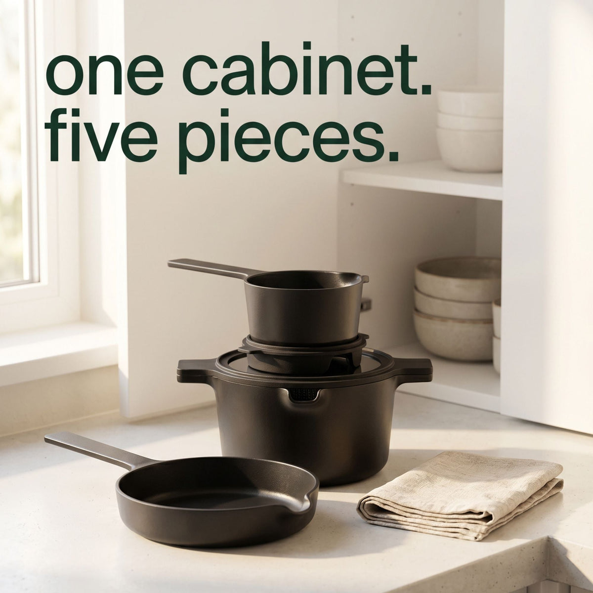 Black ceramic nonstick cookware set with two stackable pots and a frying pan