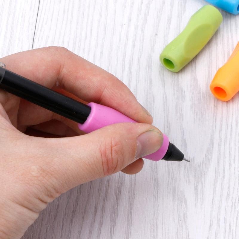 Blue, green, and orange slip-on pencil grips; hand holds black pen with pink grip
