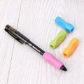 Pencil grip aid set with pink, blue, green, and orange slip-on grips