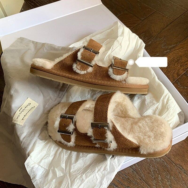 Tan-brown double-buckle faux-fur slippers in box, side view with metal adjusters