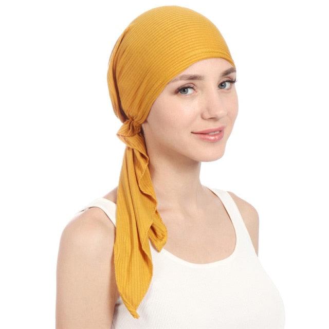 Cotton inner hijab cap in mustard yellow, side knot with draped scarf tail.