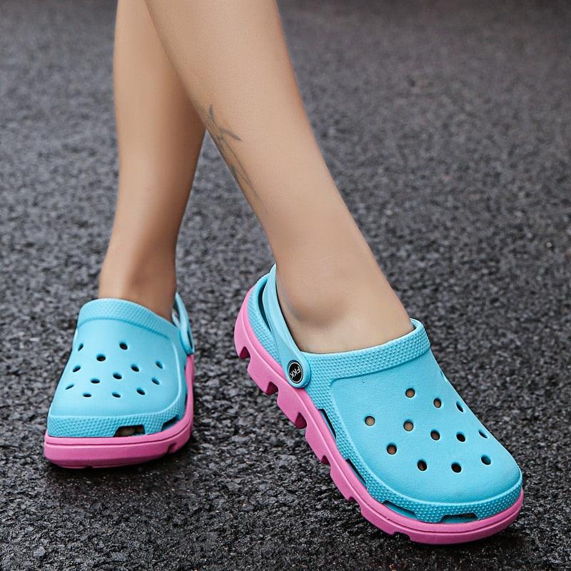 Blue perforated clogs with pink accents, side strap and rugged outsole