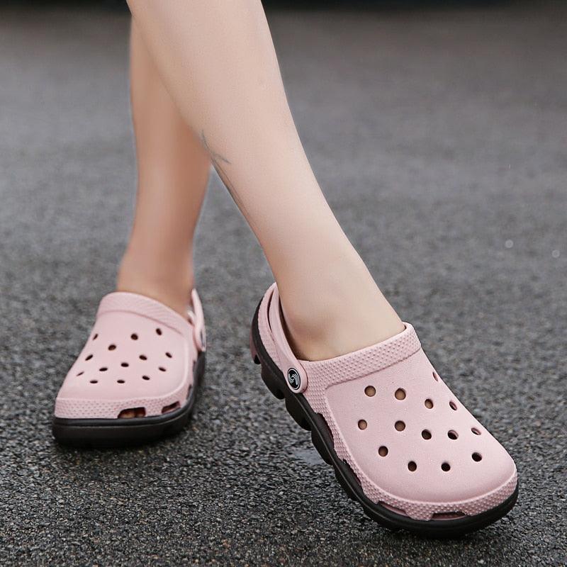 Light pink men’s perforated clogs with adjustable strap and black cushioned sole