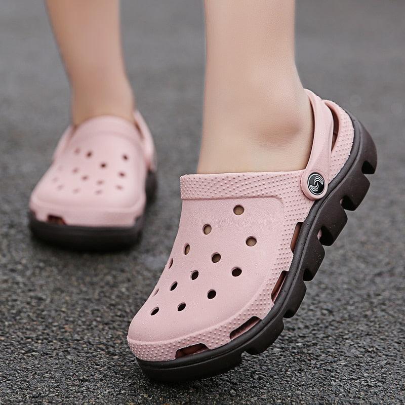 Pink perforated clogs with adjustable back strap and black outsole details