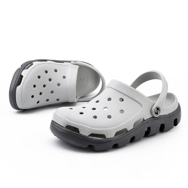 White perforated clogs with gray accents, adjustable back strap and chunky sole