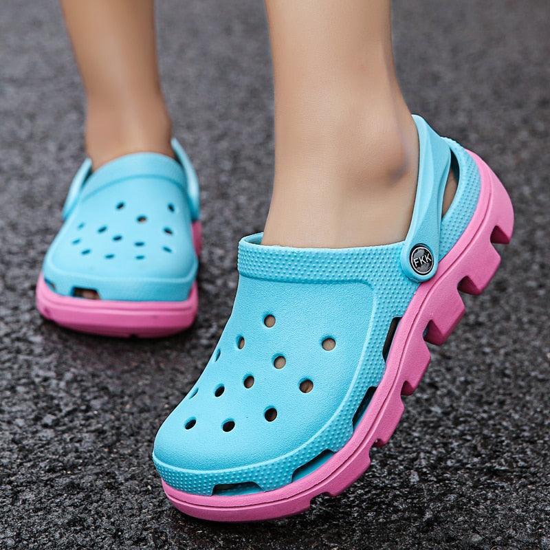 Aqua blue perforated clogs with pink side accents and adjustable back strap