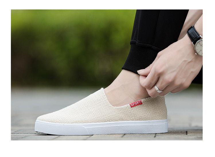 White canvas slip-on sneakers with logo patch on tongue