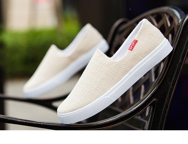 Beige canvas slip-on sneakers resting on a bench