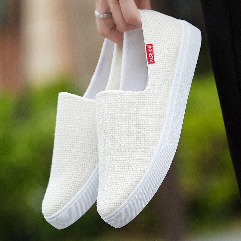 White canvas slip-on sneakers with low-profile rubber sole