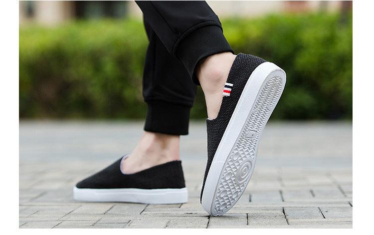 Black canvas slip-on sneakers with textured outsole visible