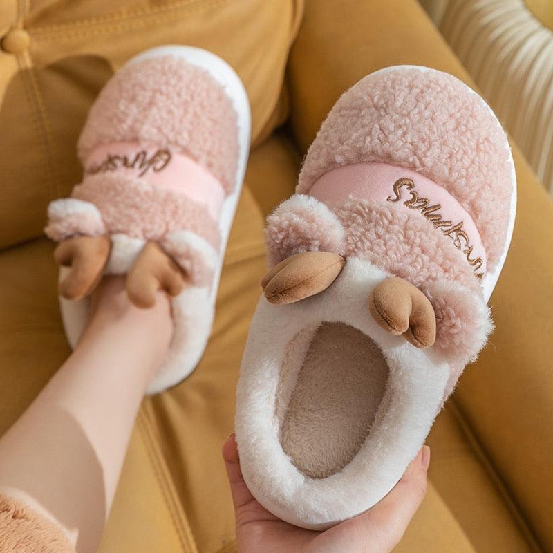 Pink plush deer Christmas slippers with antler appliques, thick white-lining sole.