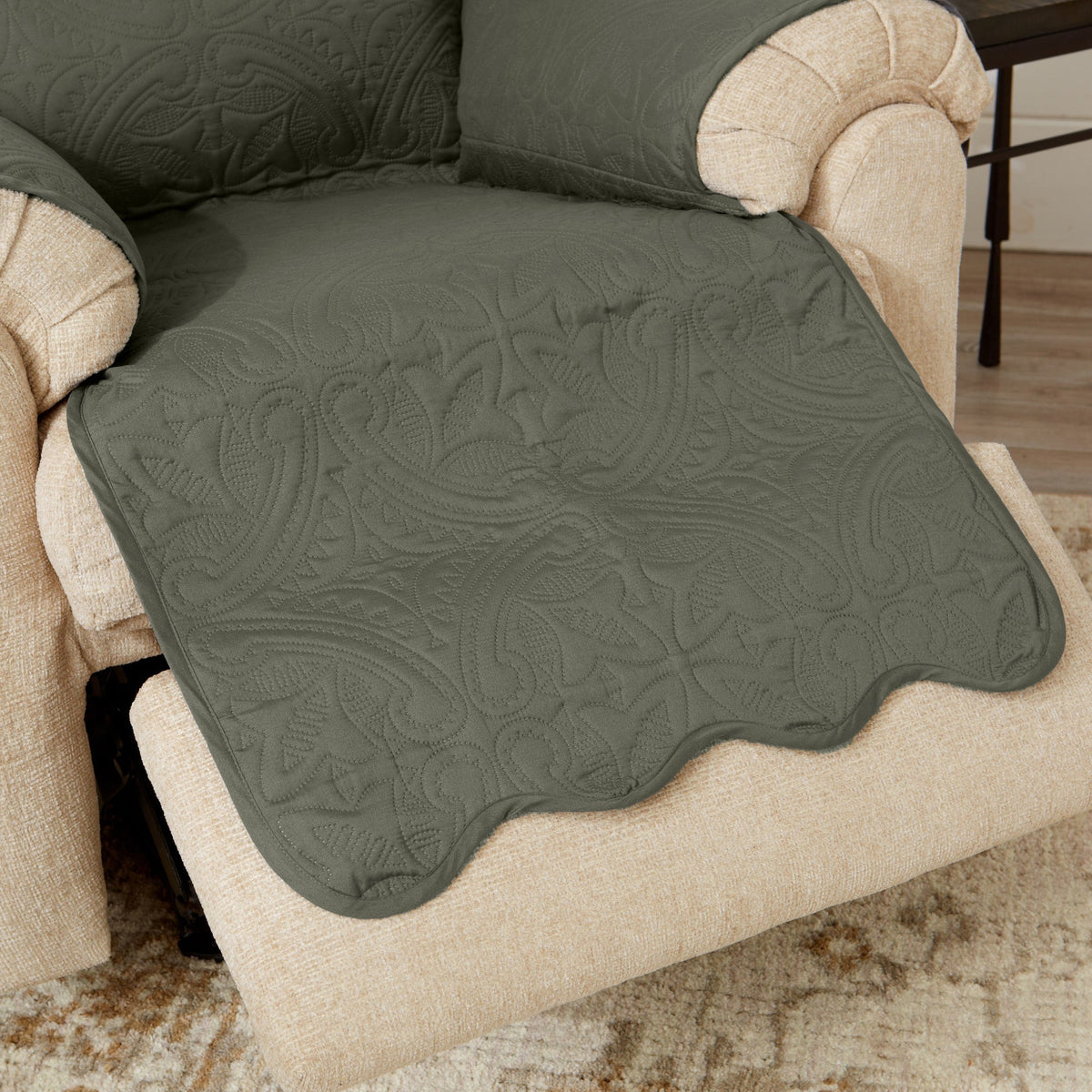 Green recliner protector blanket with quilted medallion texture and beige arm edging