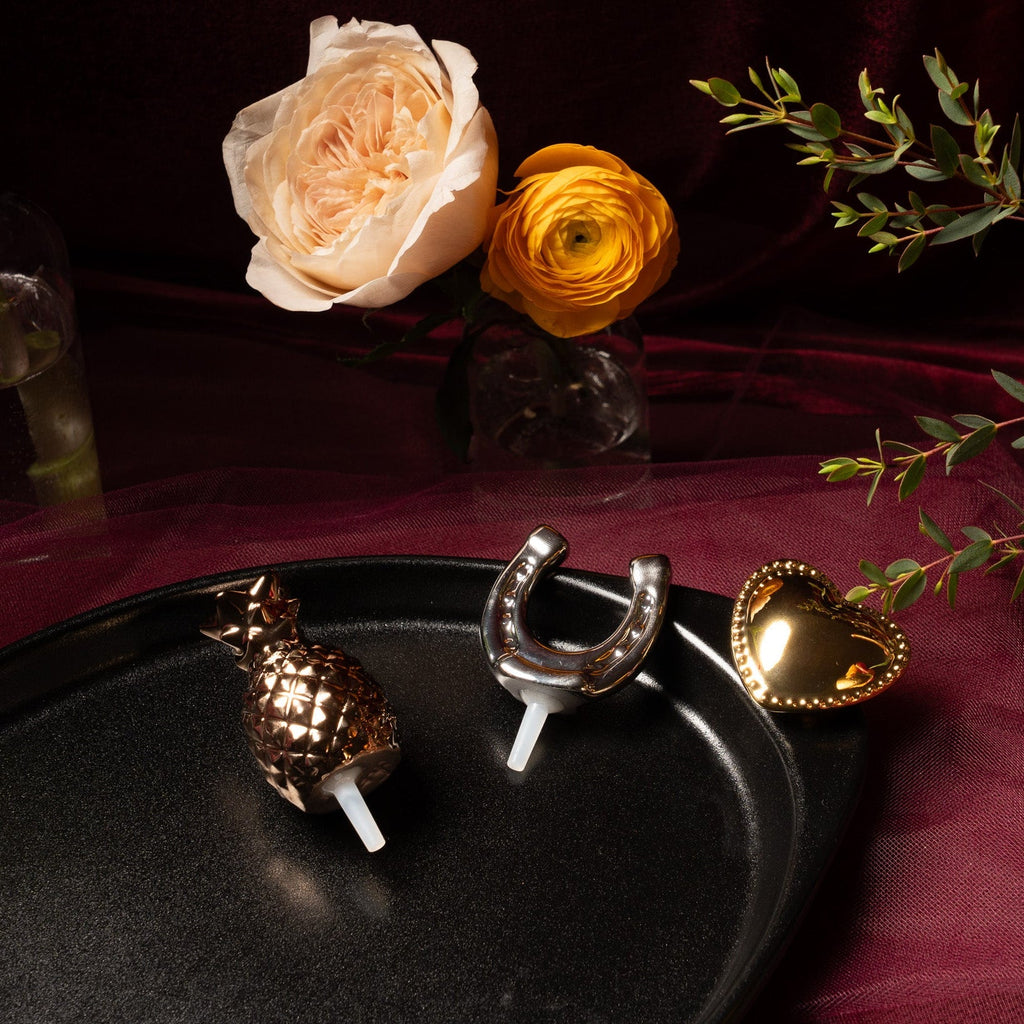 Black oval serving tray with pineapple, horseshoe, and heart decorative pieces