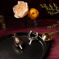 Black oval serving tray with pineapple, horseshoe, and heart decorative pieces