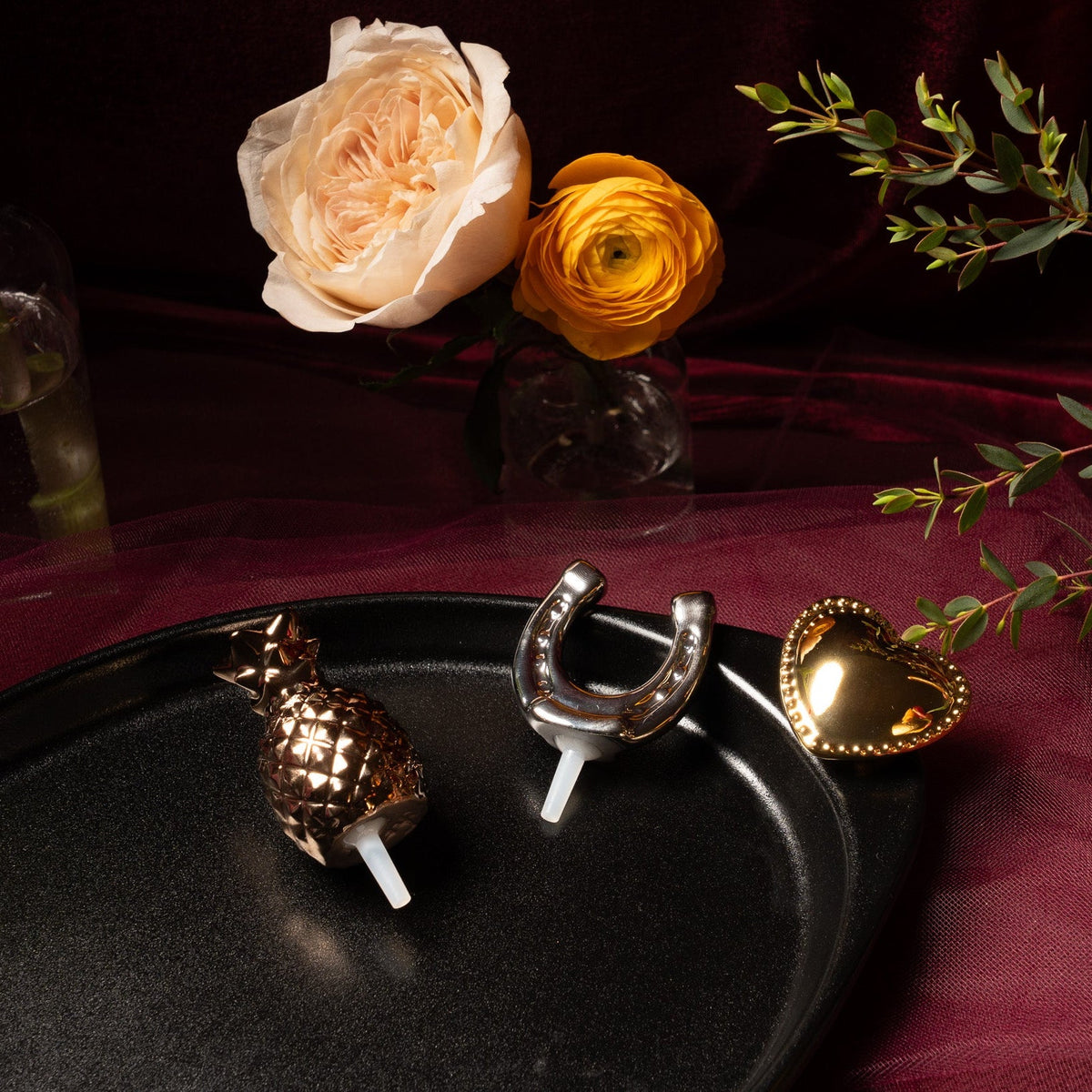Black oval serving tray with pineapple, horseshoe, and heart decorative pieces