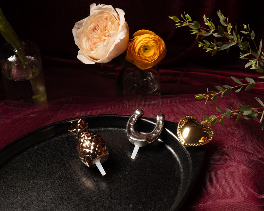Black oval serving tray with pineapple, horseshoe, and heart decorative pieces