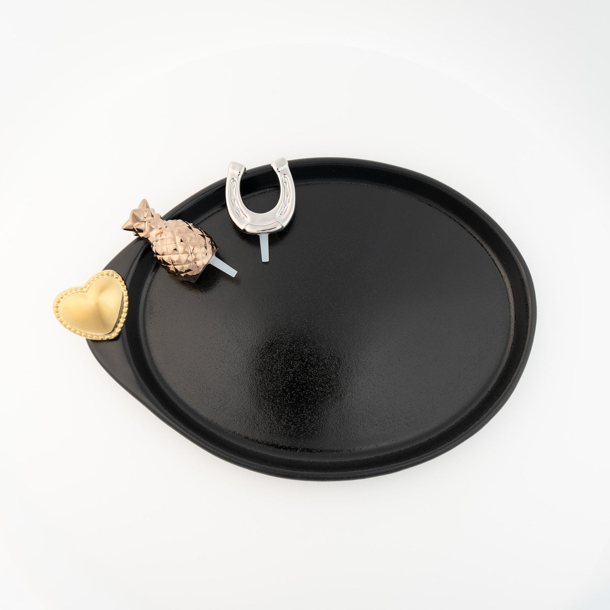 Black oval tray with pineapple, heart, and horseshoe decorative pieces