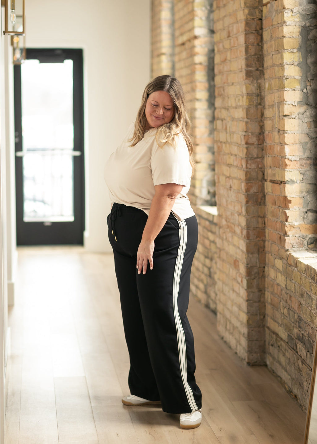 Black wide-leg track pants standing view with vertical side stripe panels