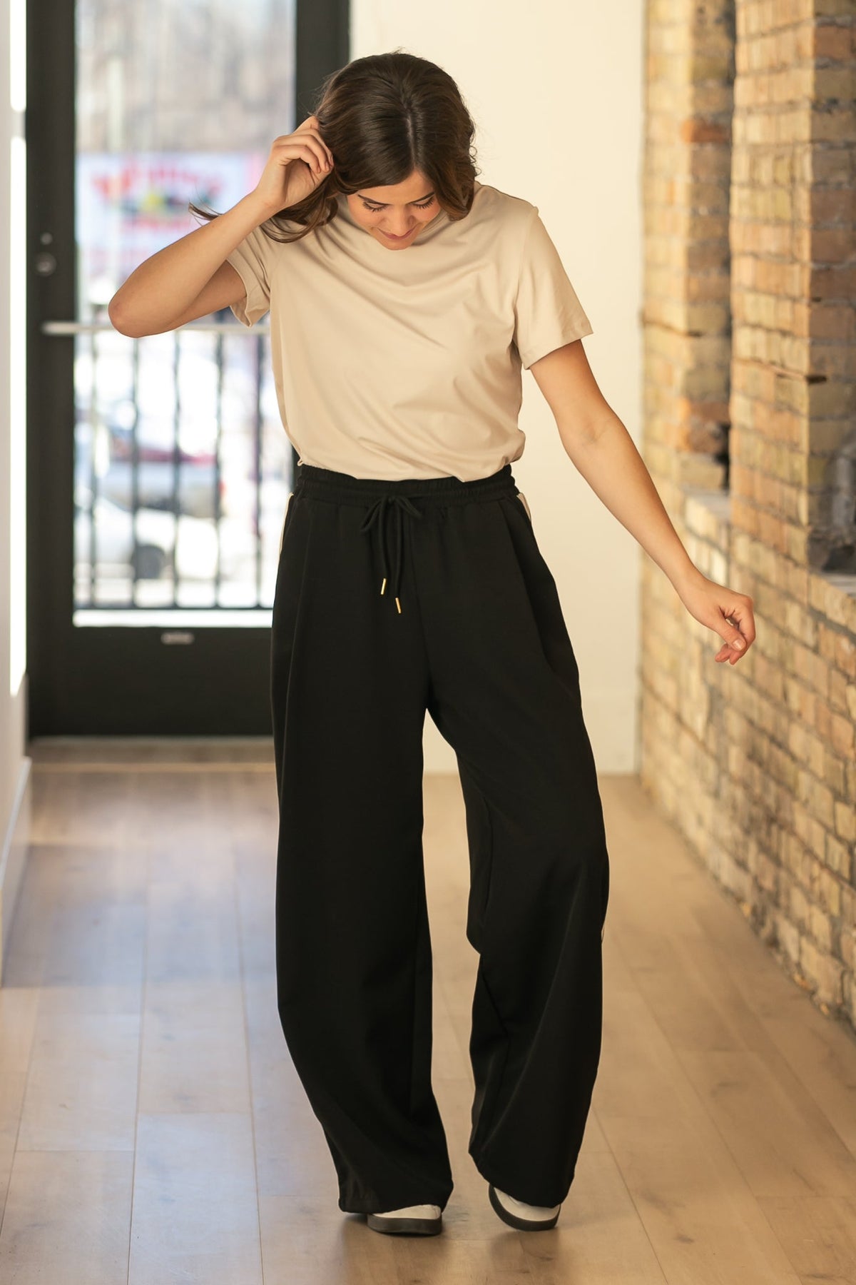 Nina wide-leg track pants in dark with relaxed leg shape and elastic waistband.