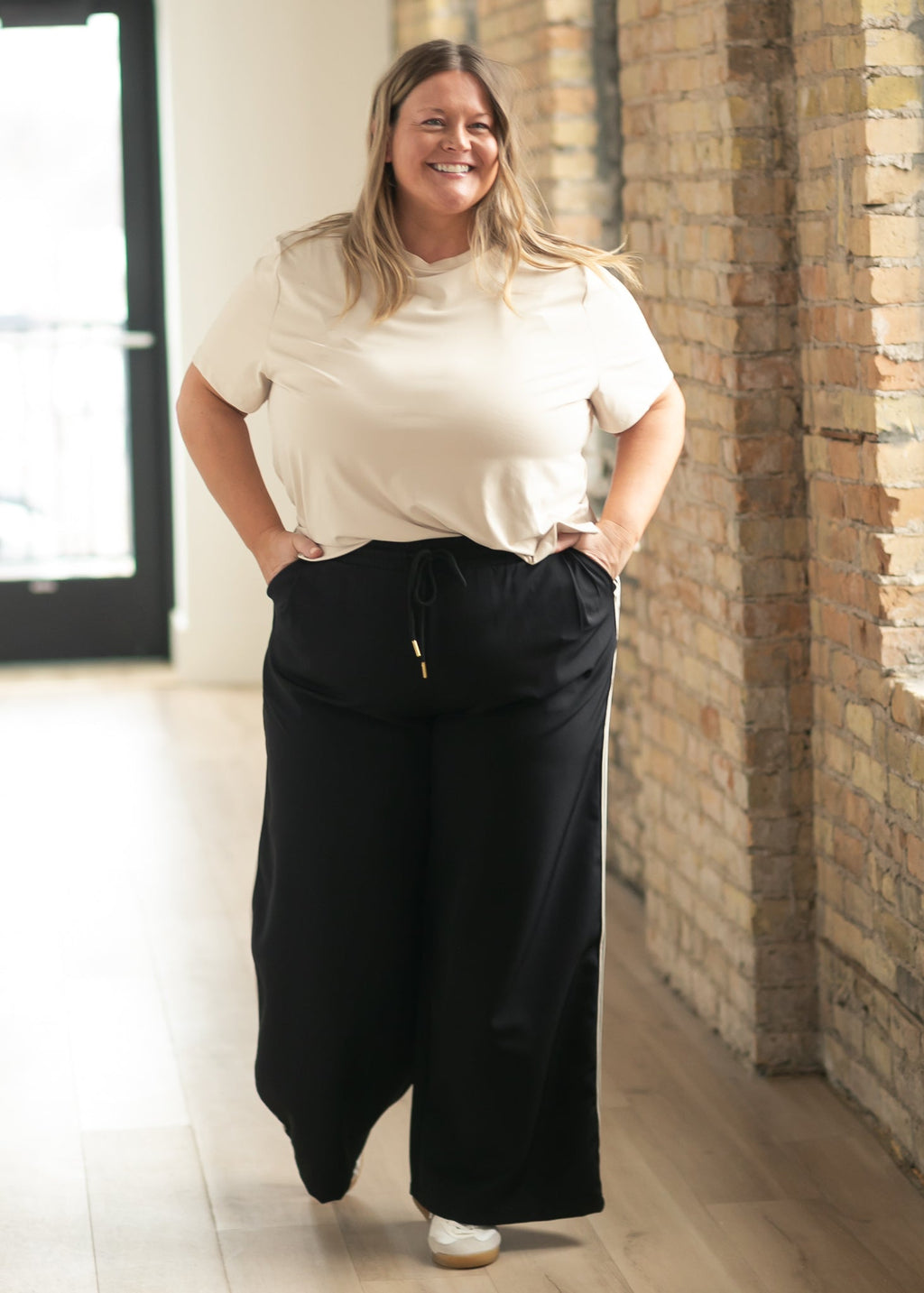 Nina wide-leg track pants in dark color with elastic waistband.