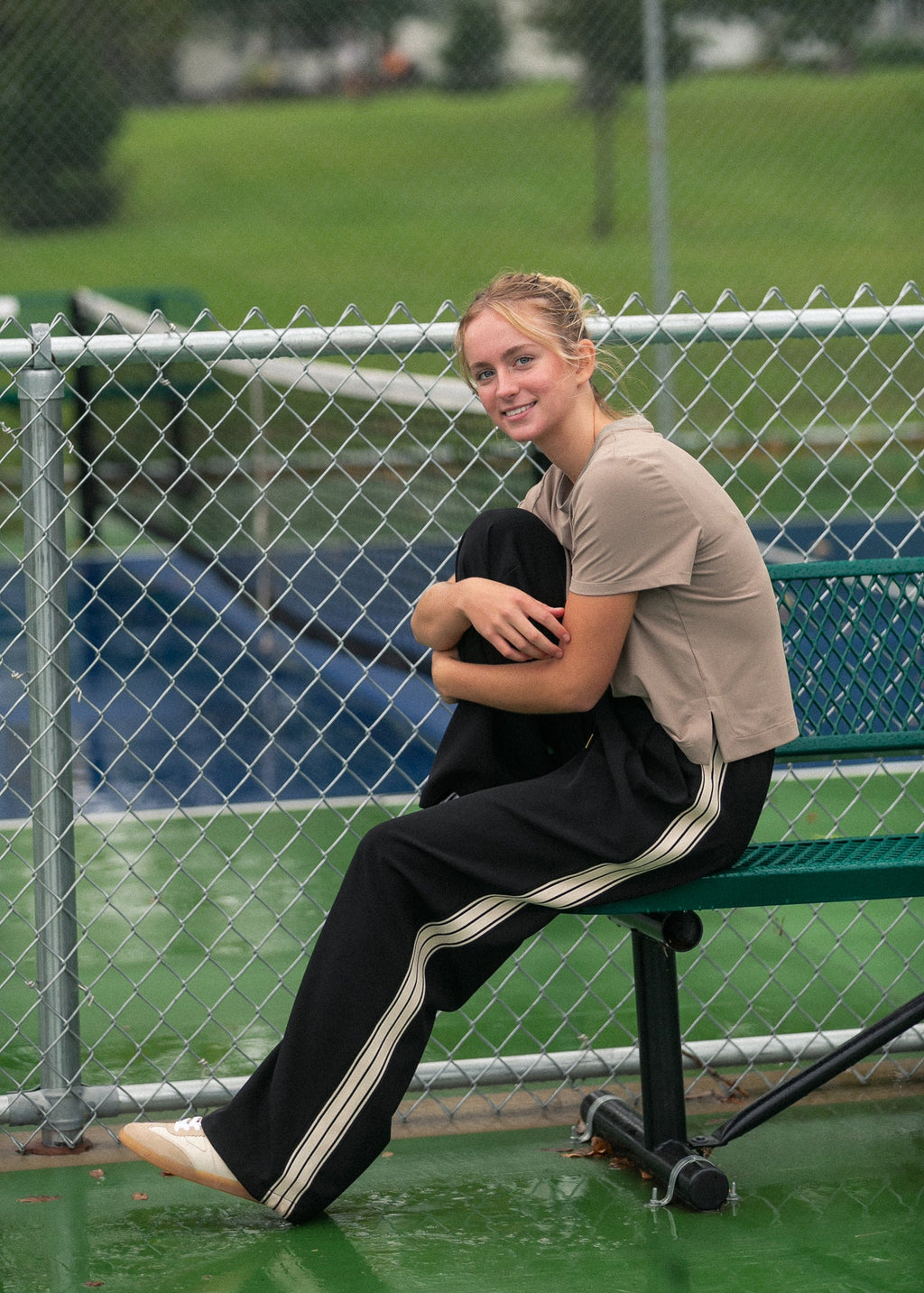 Nina wide-leg track pants in dark with white side stripes and elastic waistband.