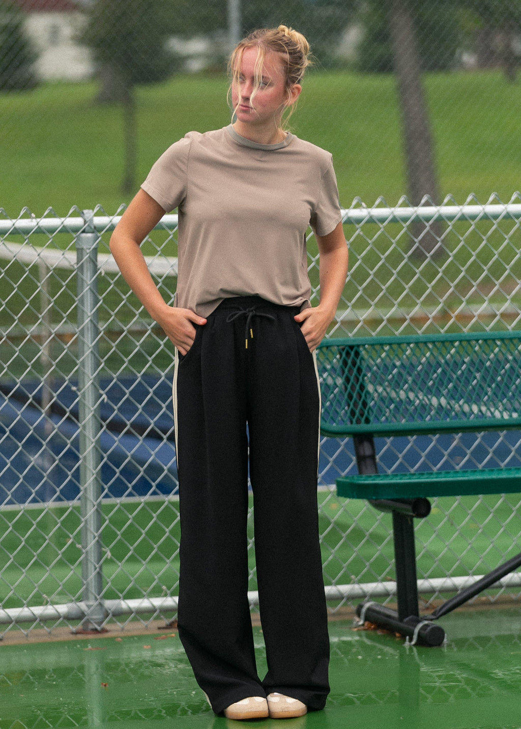 Black wide-leg track pants with white side stripes and drawstring waist