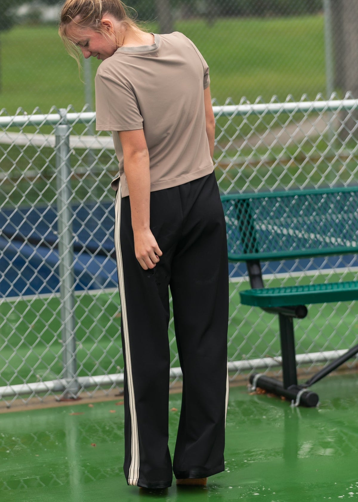 Black wide-leg track pants with vertical white side stripes and drawstring waist