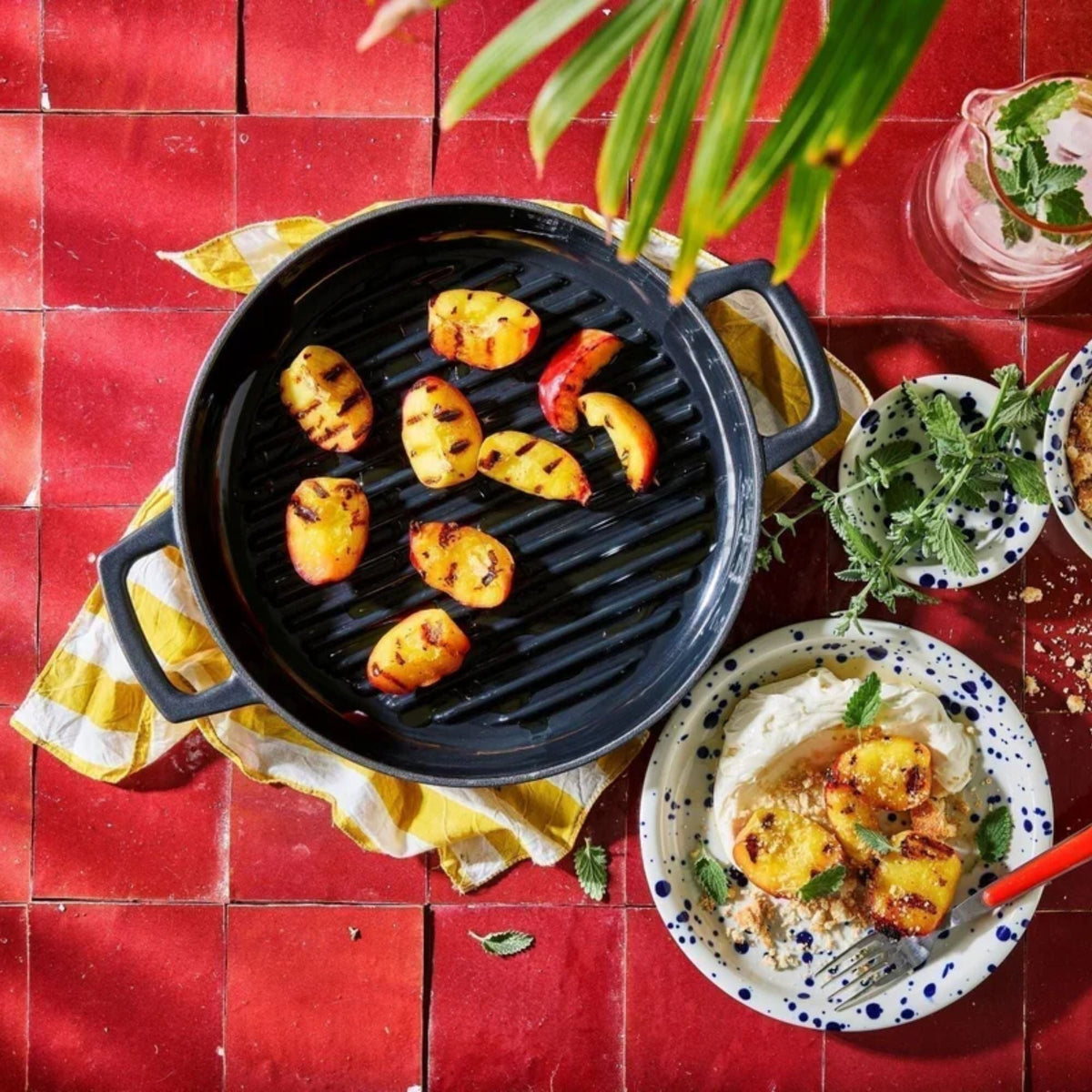 Enameled grill pan with ridged cooking grate holding sliced roasted vegetables