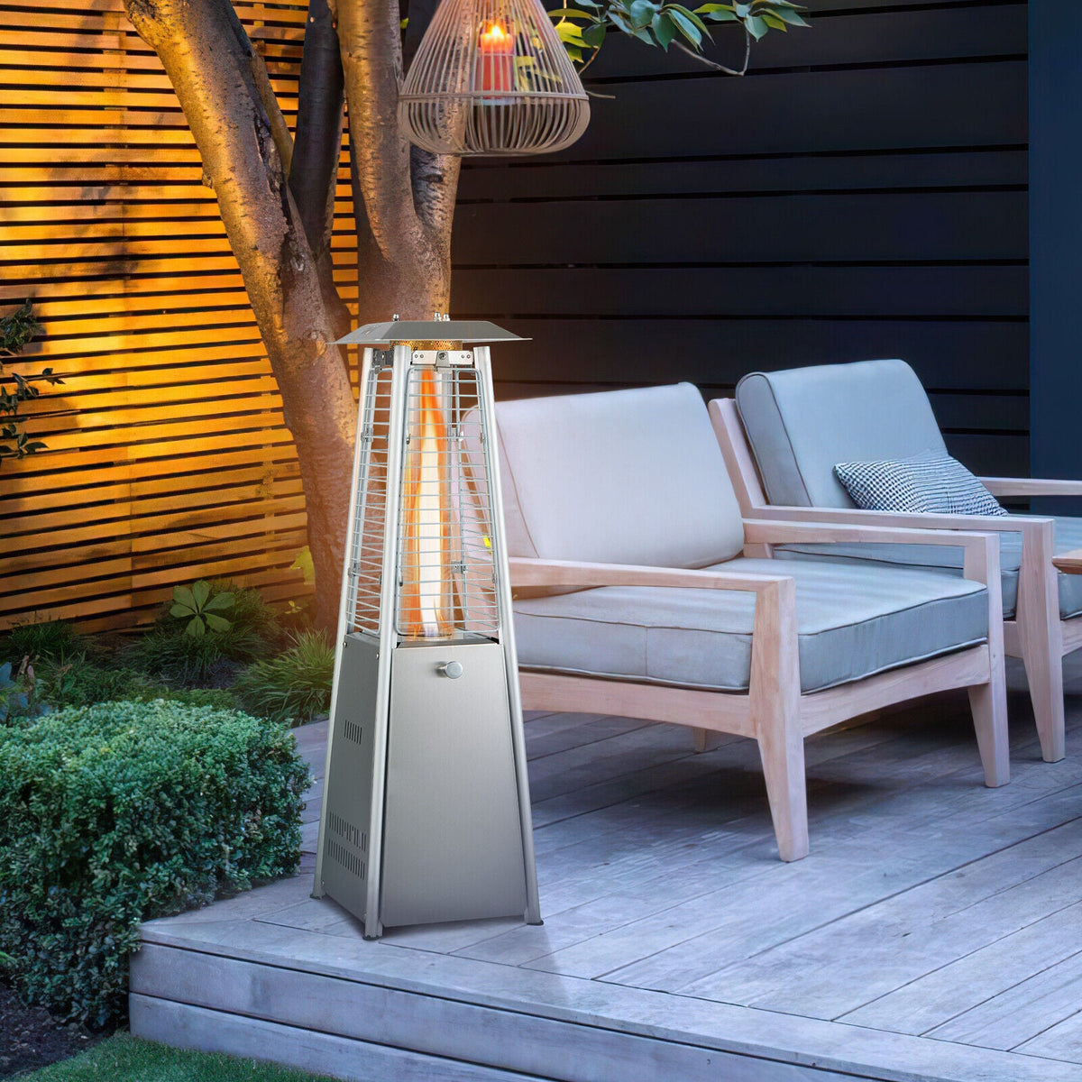Outdoor patio tabletop heater with glowing glass tube beside lounge chairs