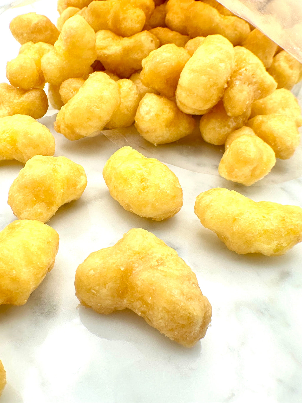 Close-up of golden beaver nugget snacks with crunchy, ridged surface pieces.
