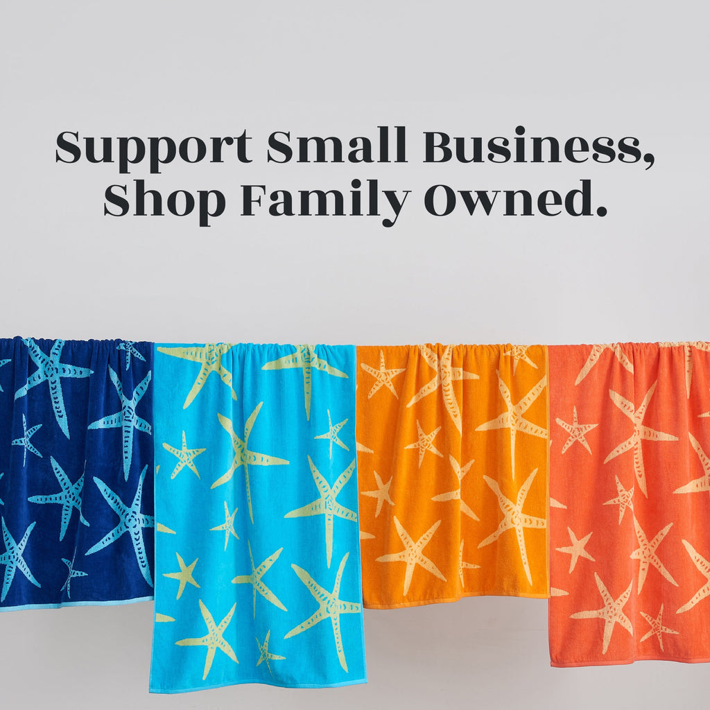 Set of blue and orange cotton velour towels with starfish prints hanging