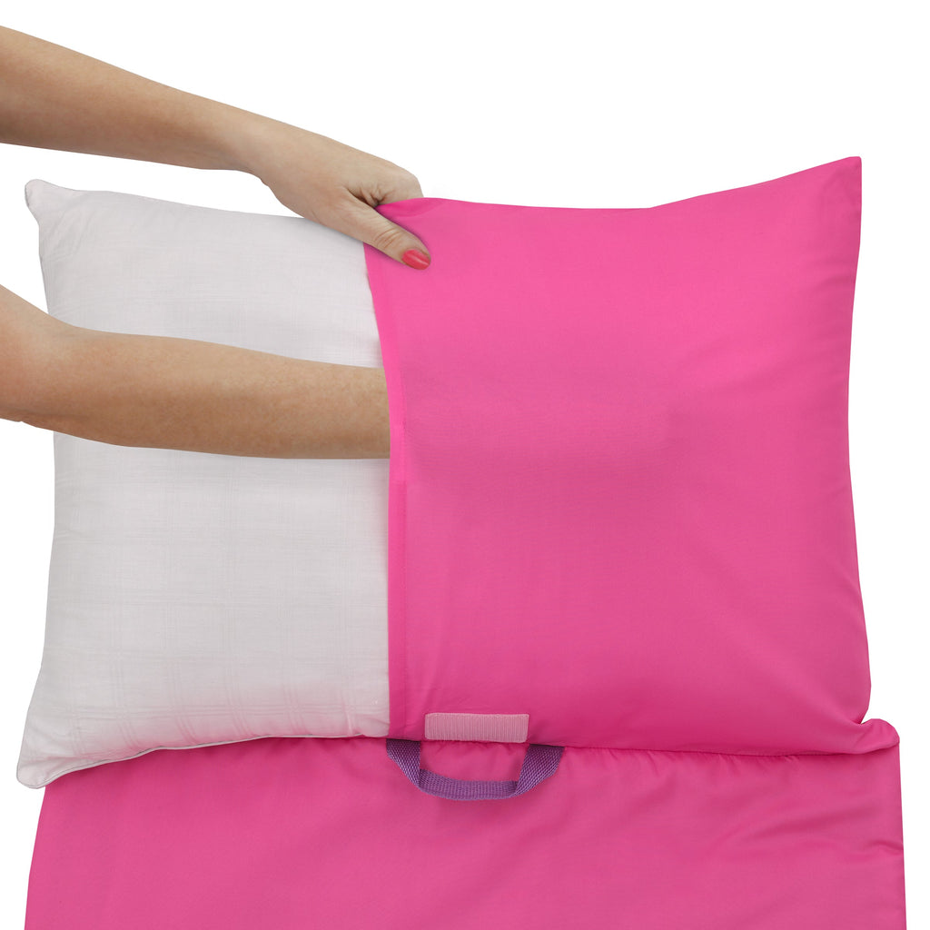 Pink nap mat cover being placed over a white pillow insert by a hand