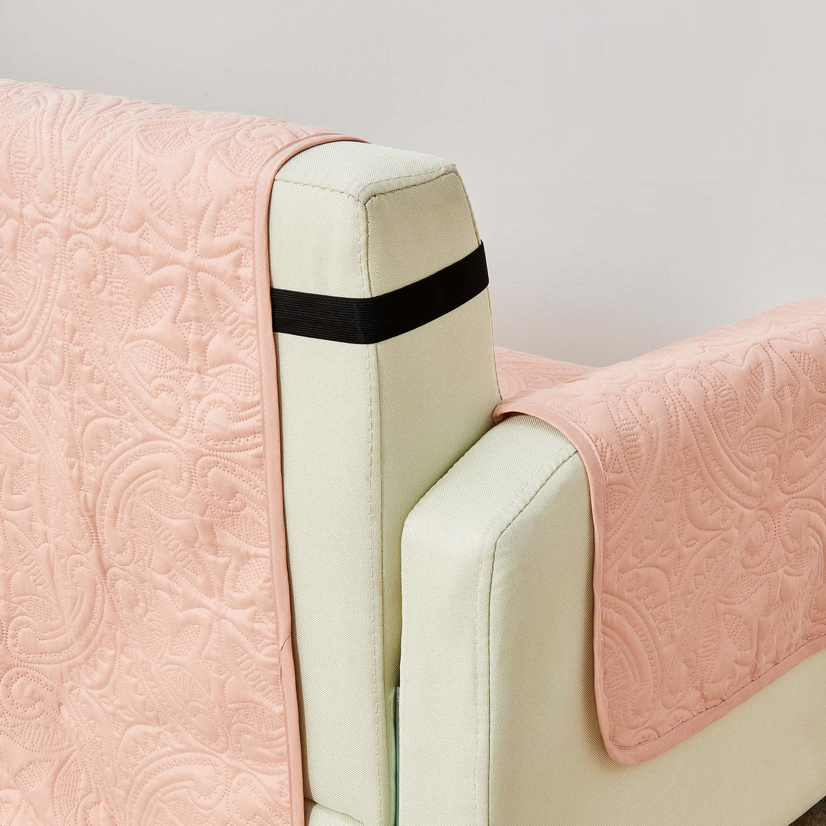 Dusty rose protector close-up with medallion quilting and black trim band