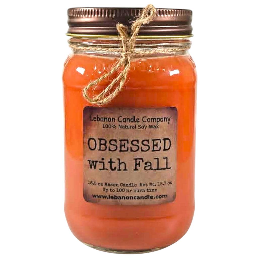 Orange jar candle with fabric-tied twine bow and printed label
