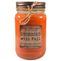 Orange jar candle with fabric-tied twine bow and printed label