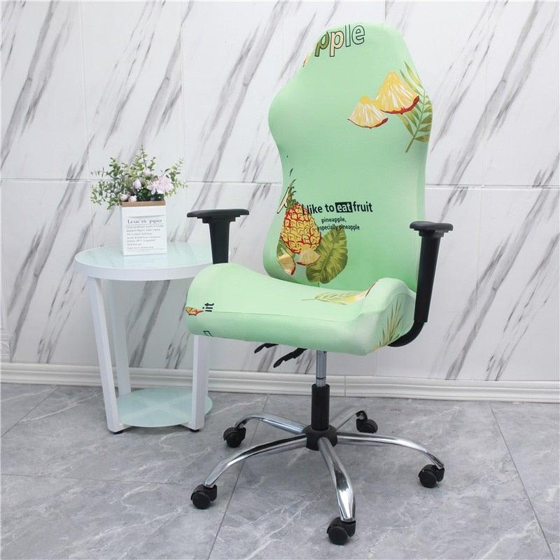 Light green stretch chair cover with fruit-themed print, fitted over seat and backrest.