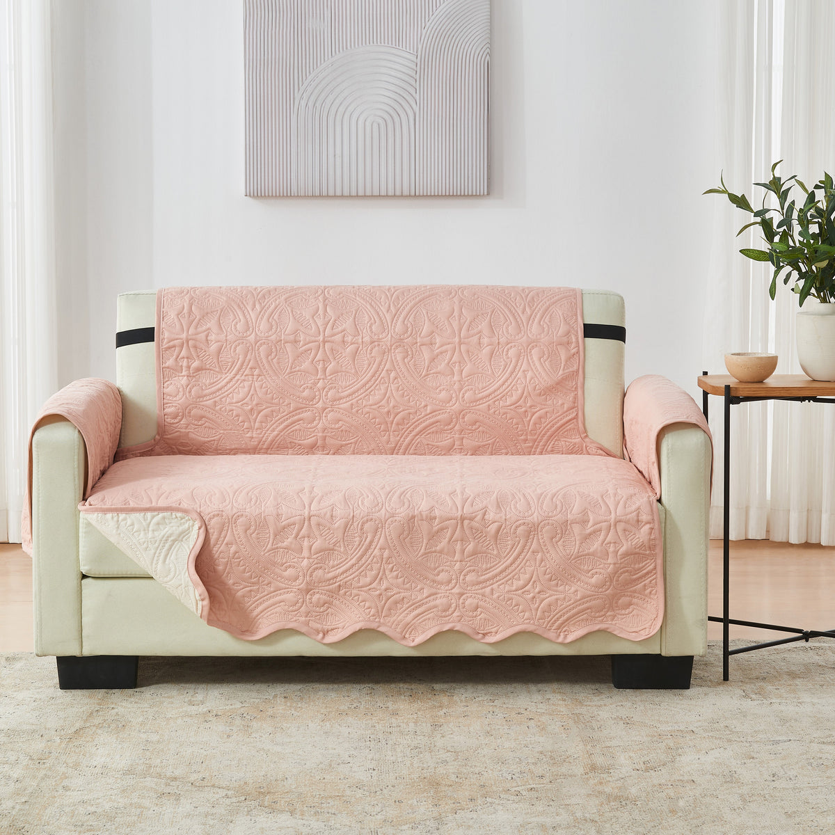 Dusty rose loveseat protector with medallion quilt pattern and black contrast trim