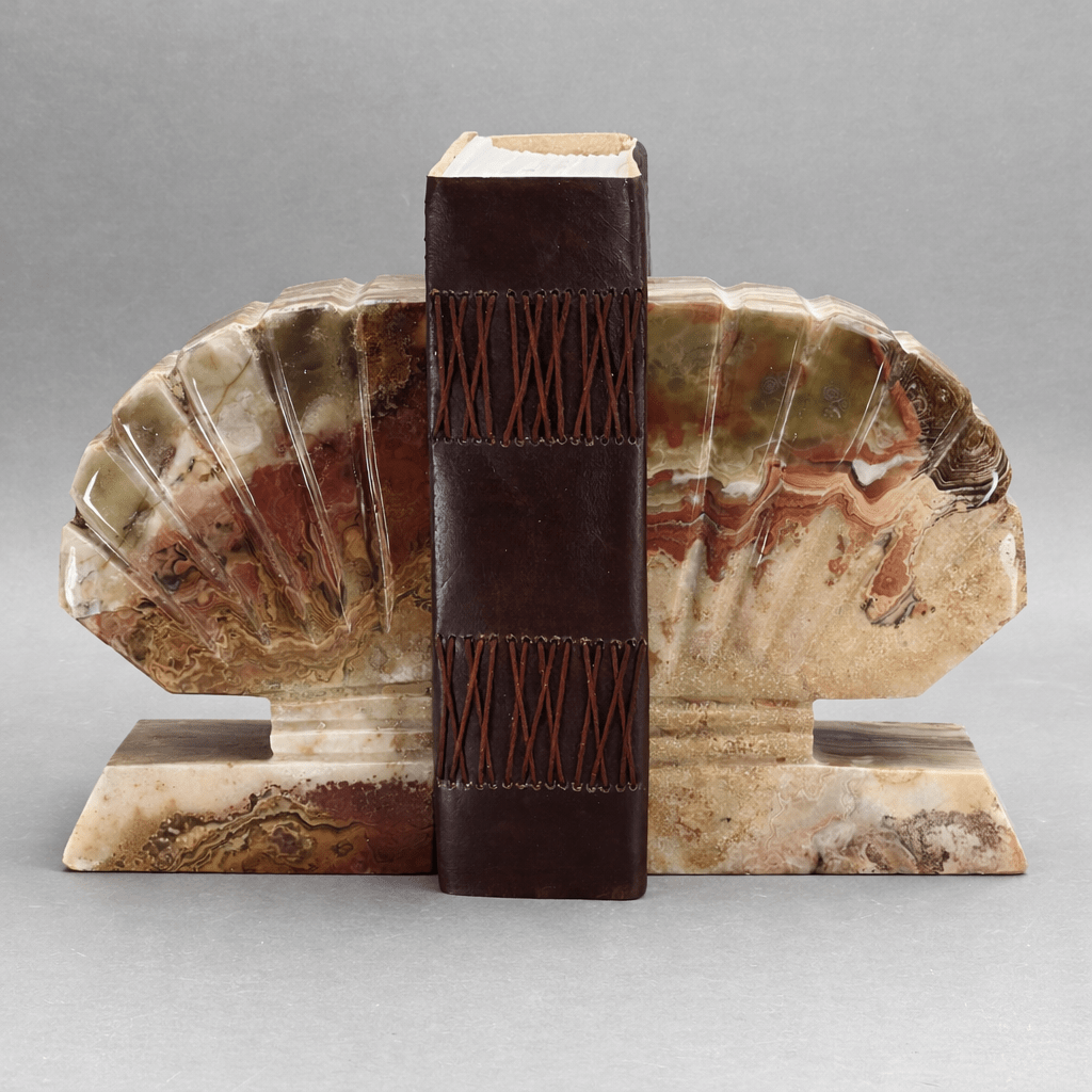 Gemstone shell bookends with upright dark book and fan-shaped shell side