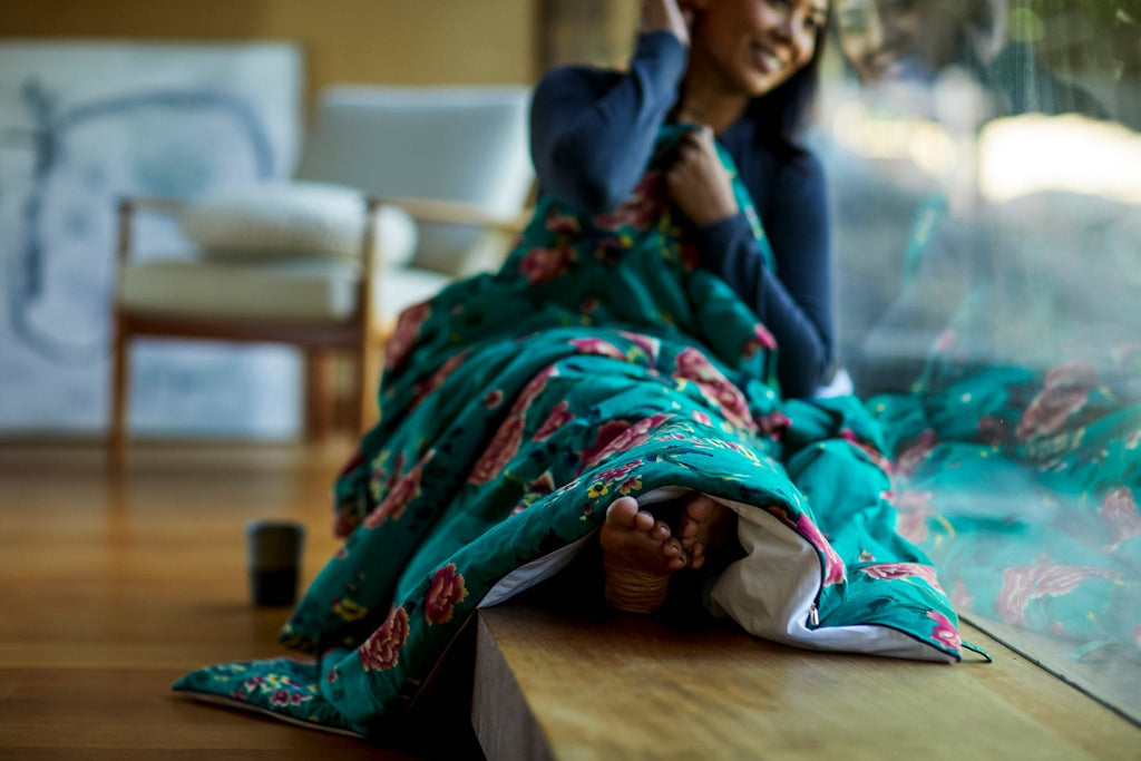 Teal floral silk throw draped on seating with matching carry pouch.