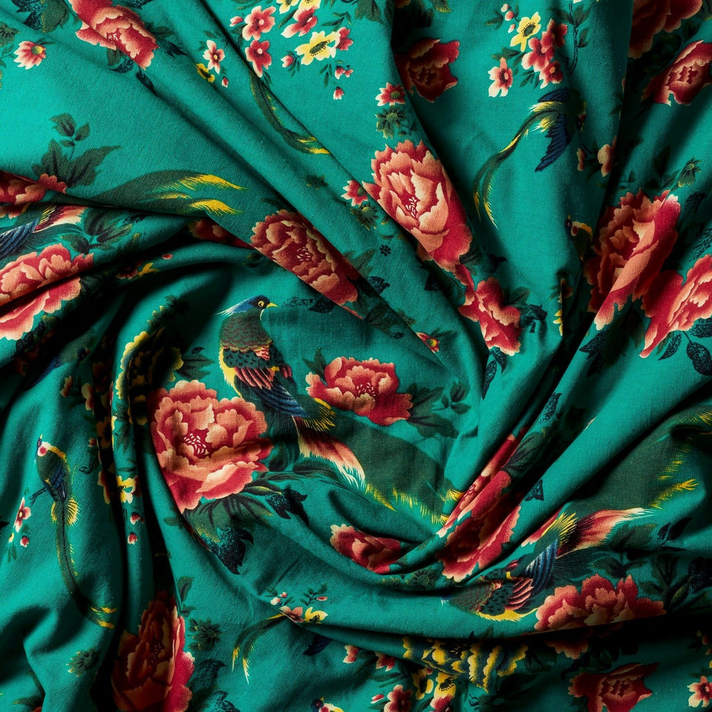 Teal floral silk throw fabric with red flowers, gathered close-up.