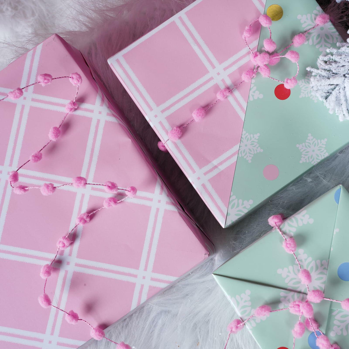 Christmas wrapping paper set with pink plaid, mint snowflake, and dot patterns; folded sheets